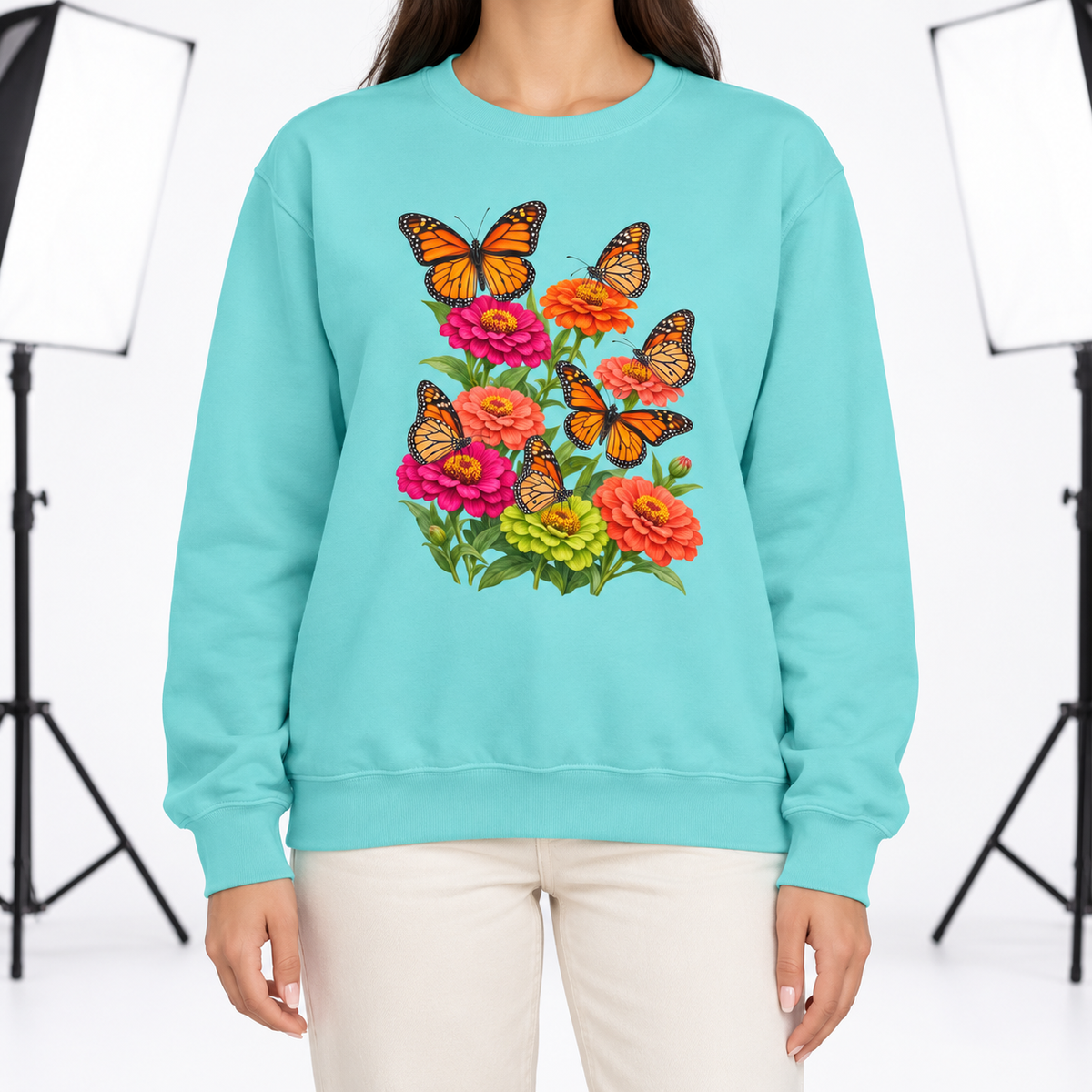 Woman wearing the Six Monarchs & Blooming Zinnias sweatshirt in Chalky Mint, six monarch butterflies over pink, orange and lime zinnias, large centered chest print