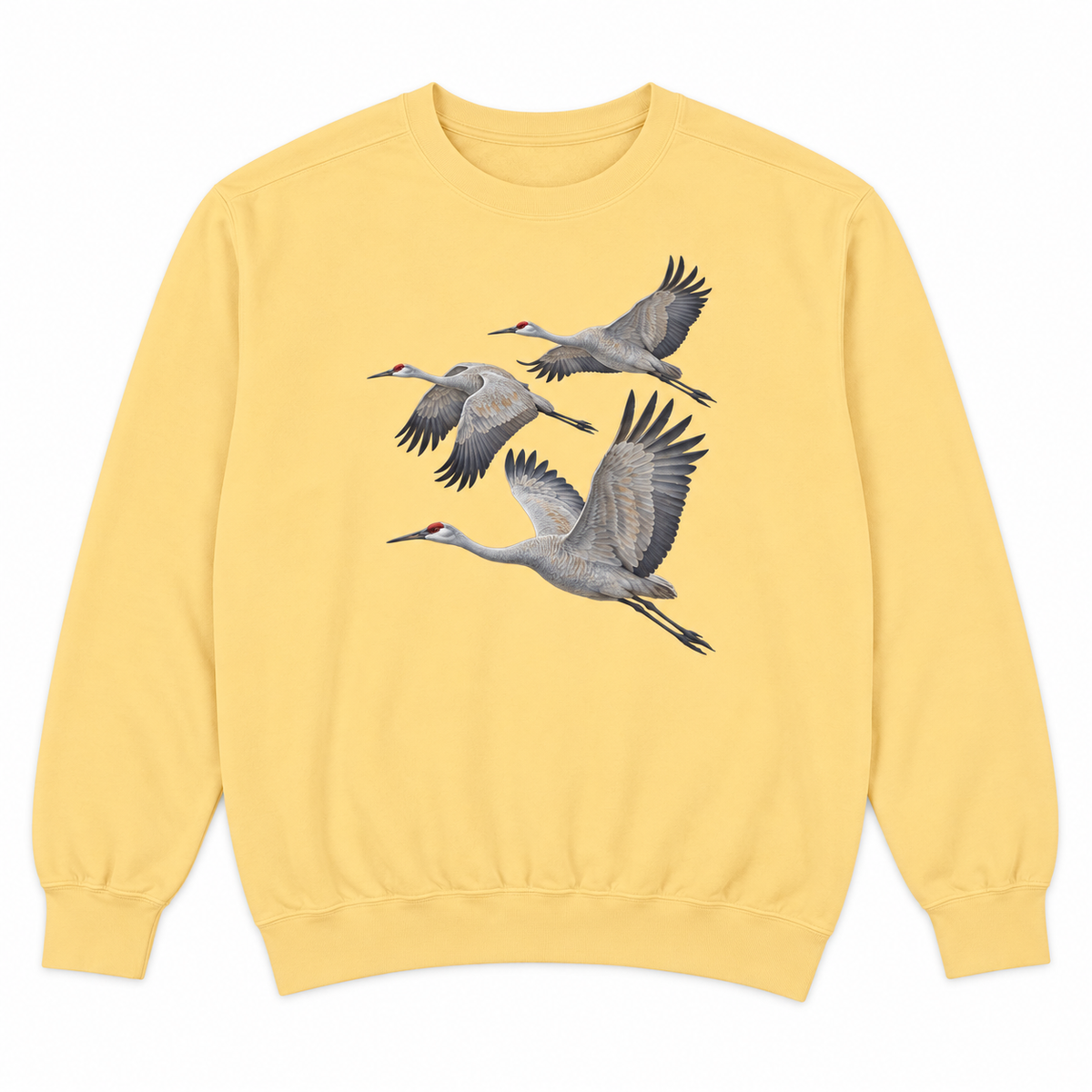 Front view of a Butter Comfort Colors 1566 crewneck sweatshirt with three sandhill cranes in flight printed on the chest, no text, laid flat