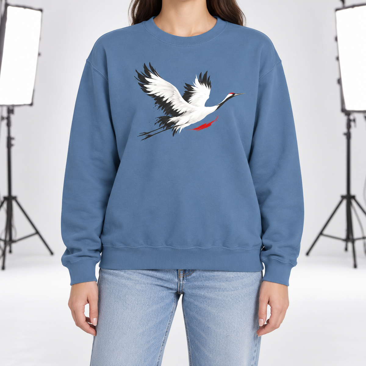 Blue Jean Comfort Colors 1566 crewneck sweatshirt with a minimalist red-crowned crane in flight printed on the chest, worn by a model