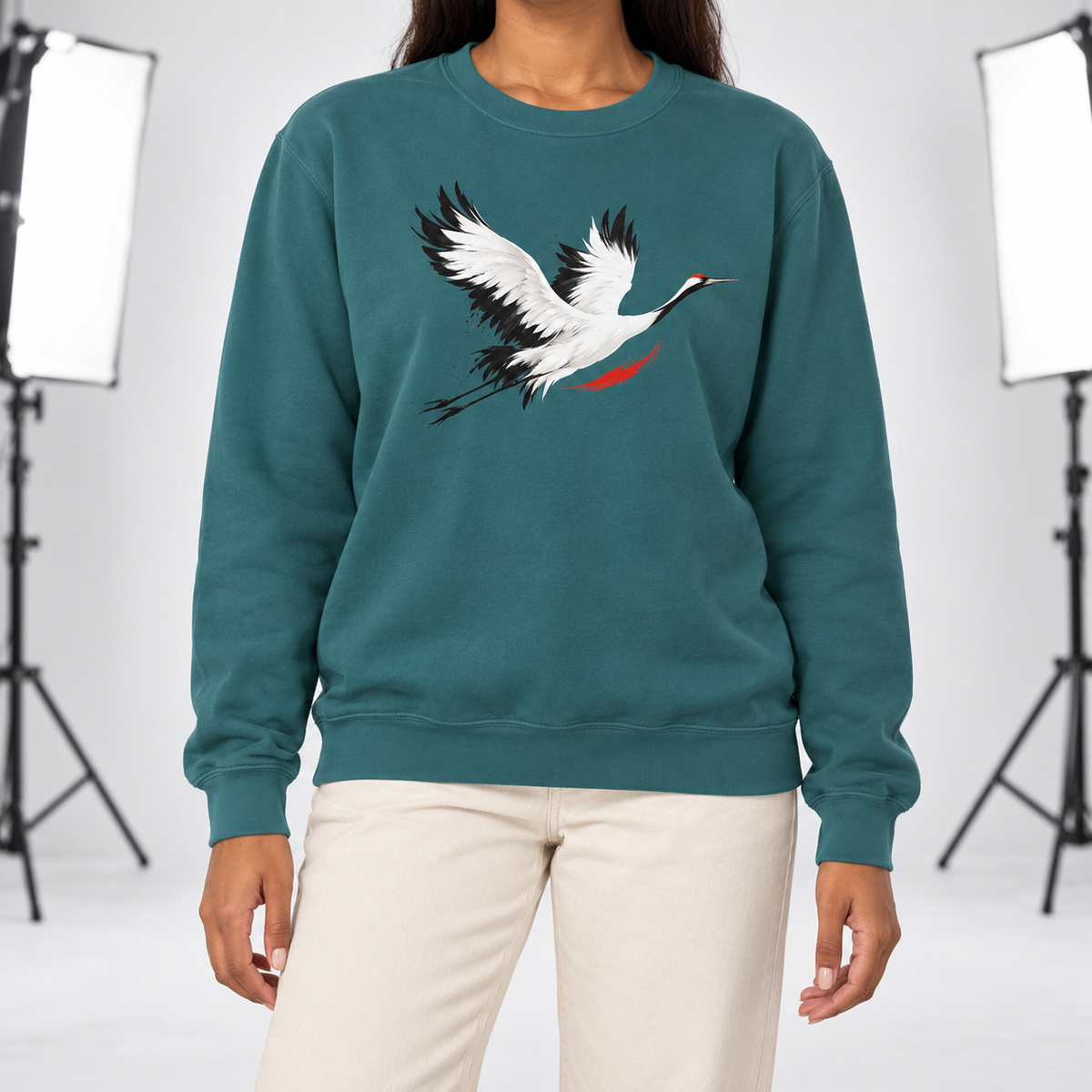 Blue Spruce Comfort Colors 1566 crewneck sweatshirt with a minimalist red-crowned crane in flight printed on the chest, worn by a model