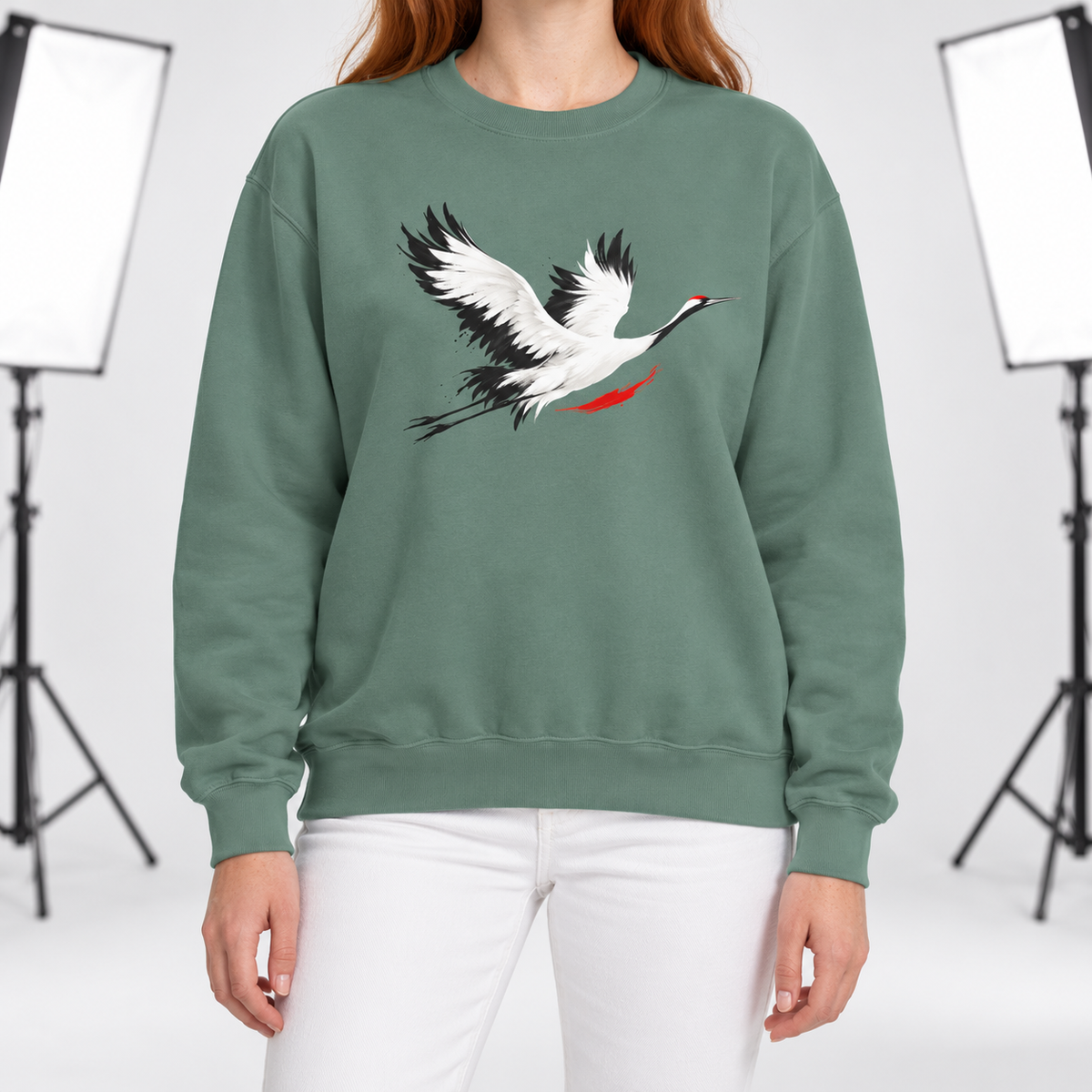 Light Green Comfort Colors 1566 crewneck sweatshirt with a minimalist red-crowned crane in flight printed on the chest, worn by a model